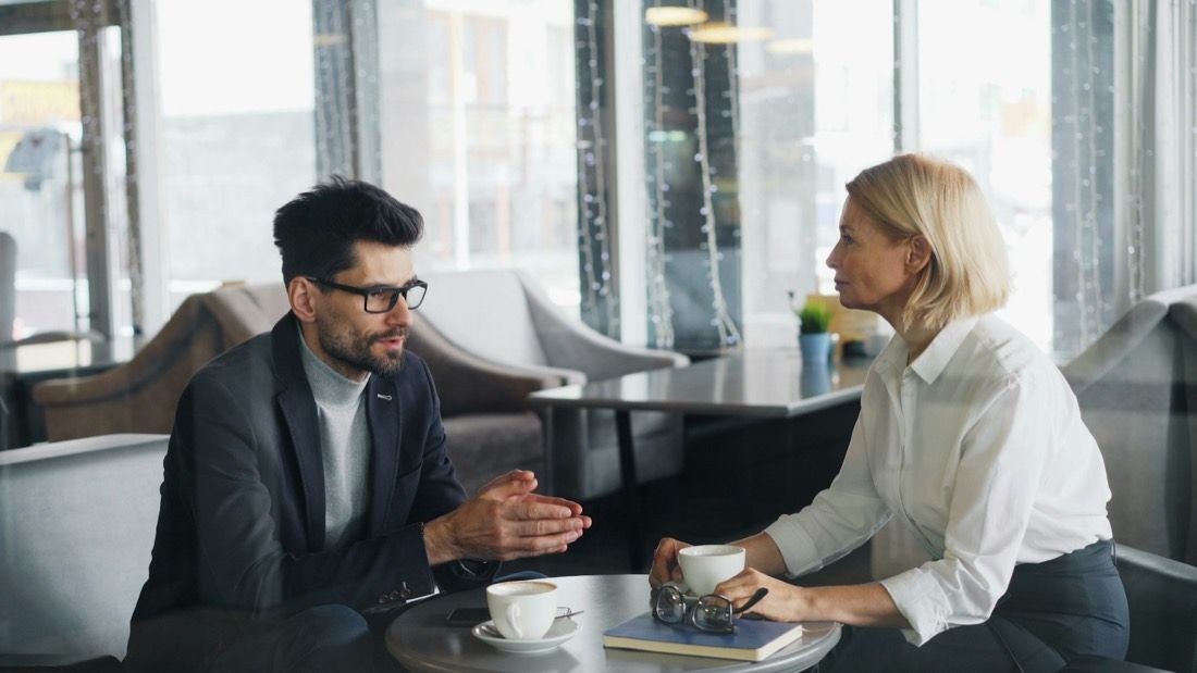 Adviseur in gesprek met een klant aan tafel